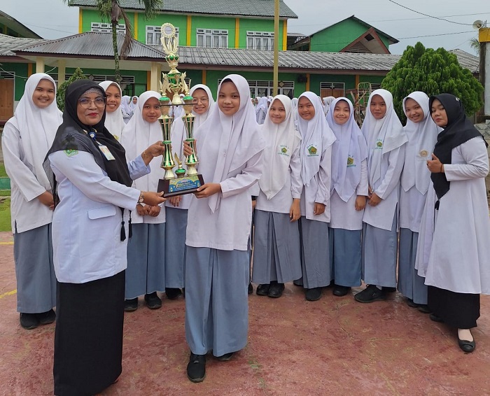 Kepala MAN 1 Padangsidimpuan Dra Hj Wasliah Lubis, SPd, MA, menyerahkan hdiah kepada perwakilan Group Nasyid MAN 1 Padangsidimpuan yang meraih Juara II Festival Qasidah Rebana Klasik II PC Fatayat Nahdlatul Ulama Padangsidimpuan usai Upacara Hari Kesaktian Pancasila, Selasa ( 1/10/2024). Waspada/ist.