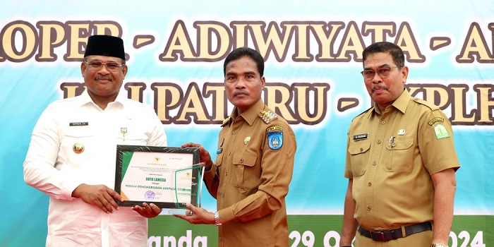 Pj Gubernur Aceh, Safrizal ZA, didampingi Kadis LHK Aceh, A. Hanan, saat menyerahkan penghargaan lingkungan hidup kategori Adipura, kepada Kota Langsa, yang langsung diterima Pj Wali Kota Langsa, Syaridin,, di Taman Kota Tibang, Banda Aceh, Selasa (29/10). (Waspada/Zafrullah)