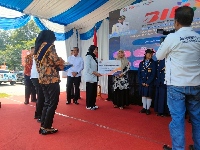 Analis Deputi Direktur Pengawasan perilaku Pelaku Usaha Jasa Keuangan, Edukasi dan Perlindungan Konsumen OJK Paramita Yulia Nasution menyerahkan KUR kepada pelaku UMKM pada Bulan Inklusi Keuangan Deliserdang Tahun 2024 di pelataran Plaza Kuliner Deliserdang, Rabu (30/10). (Waspada/Khairul K Siregar/B)