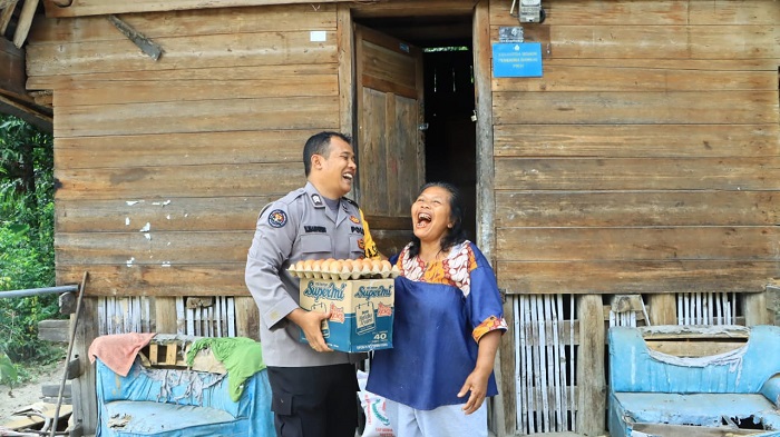 KASI Humas Polres Samosir, Brigadir Vandu Marpaung saat menyerahkan bantuan sembako kepada keluarga yang kurang mampu. Waspada/Ist.