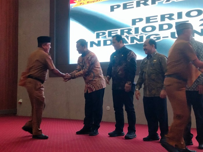 Pj Bupati Deliserdang Wiriya Alrahman didampingi Pj Sekdakab Citra Effendi Capah, Asisten Perekonomian dan Pembangunan Setdakab Deliserdang Khoirum Rijal memberi ucapan selamat kepada salah seorang Kepala Desa yang menerima SK perpanjangan masa jabatan di Grha Bhineka Perkasa Jaya, Jumat (4/10). (Waspada/Khairul K Siregar/B)