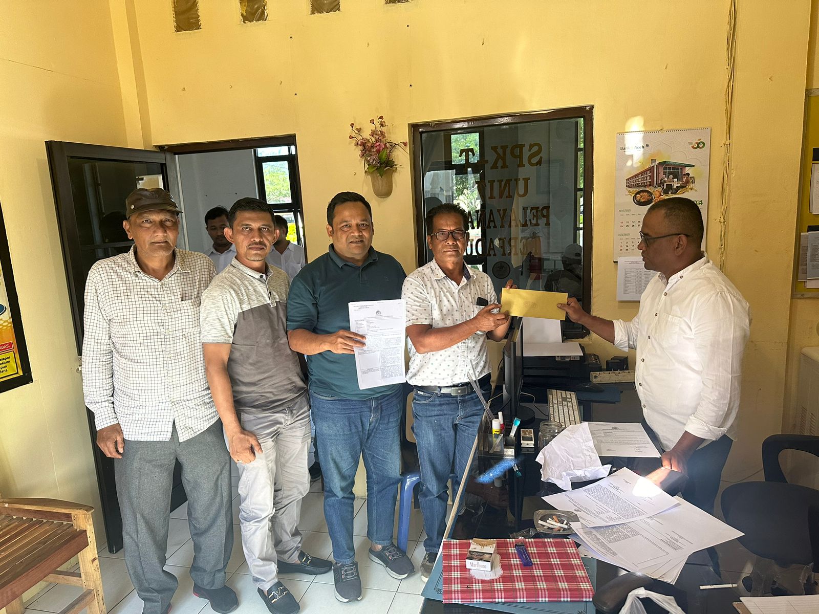 Safuan didampingi Asrizal,Ketua RKB calon Gubernur dan Wakil Gubernur Aceh, Bustami Hamzah- H.Fadil Rahmi saat melaporkan kasus dugaan pengancaman ke Polres Aceh Tamiang,Senin (11/11). (Waspada/Ist).