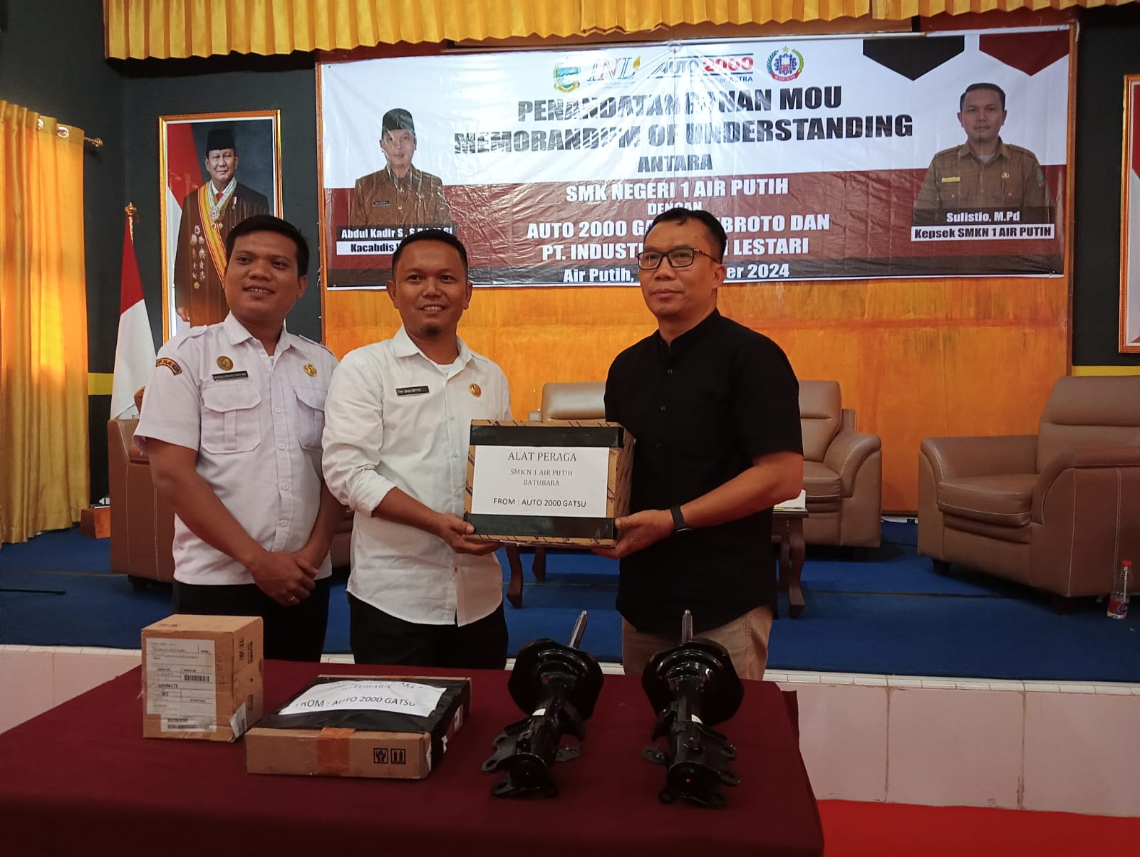 Kepala SMKN 1 Airputih Sulistio menerima bahan praktik dari Auto 2000 Medan yang diserahkan Sudarto setelah penandatanganan MoU.(Waspada/Agusdiansyah Hasibuan)