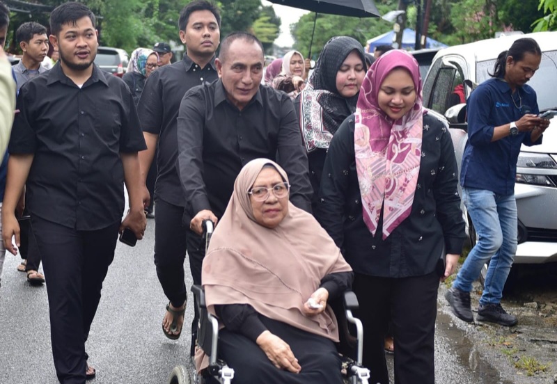 CAGUBSU Edy Rahmayadi, bersama ibunda Hj. Ngadisah Kandar, dan anak serta menantu, berjalan menuju TPS dari kediamannya. Waspada/Ist