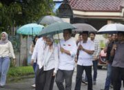 Mesra Sepayung Bersama Istri Tercinta, Profesor Ridha Ditemani Ketiga Putrinya Nyoblos Di TPS 23 Medan Selayang