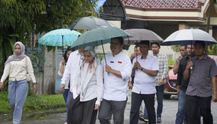 Mesra Sepayung Bersama Istri Tercinta, Profesor Ridha Ditemani Ketiga Putrinya Nyoblos Di TPS 23 Medan Selayang