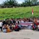Usai melakukan aksi, seratusan massa melakukan foto bersama dengan latar belakang spanduk besar dan kondisi jalan aspak yang terkelupas, Senin (11/11).(Waspada/ist).