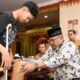 Pj Gubernur Aceh, Safrizal ZA, saat menyerahkan bantuan sekaligus memasangkan kaki palsu kepada Guntur Yuddha Pratama (14), di Meuligoe Gubernur Aceh, Selasa, (5/11). (Waspada/Zafrullah)