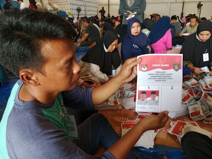 Petugas pelipatan sedang melipat surat suara Bupati dan Wakil Bupati Asahan yang berhadapan dengan kotak kosong. Waspada/Sapriadi