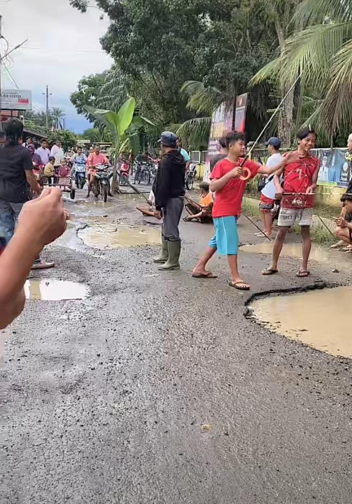 Warga Langkat Mancing Di Tengah Jalan