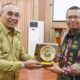 Bupati Simalungun Anton Saragih menyerahkan plakat kepada Kepala BPK RI Perwakilan Provinsi Sumut, Paula Henry Simatupang dalam rangkaian kegiatan entry meeting di Balai Harungguan Djabanten Damanik Kantor Bupati Simalungun, Selasa (11/3).(Waspada/ist).