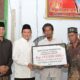 Wakil Gubernur Aceh, H. Fadhlullah, SE, saat menyerahkan santunan Ramadhan senilai Rp315 juta dari Muzaki Baitul Mal Aceh untuk dibagikan kepada 315 mustahik di Bireuen, Kamis (12/3). (Waspada/Ist)