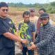 MASYARAKAT Desa Sitapongan, Andi Lumban Gaol menerima bibit pohon durian dari pihak pengusaha untuk ditanam di lahan bukaan pertanian. Waspada/Andi Siregar