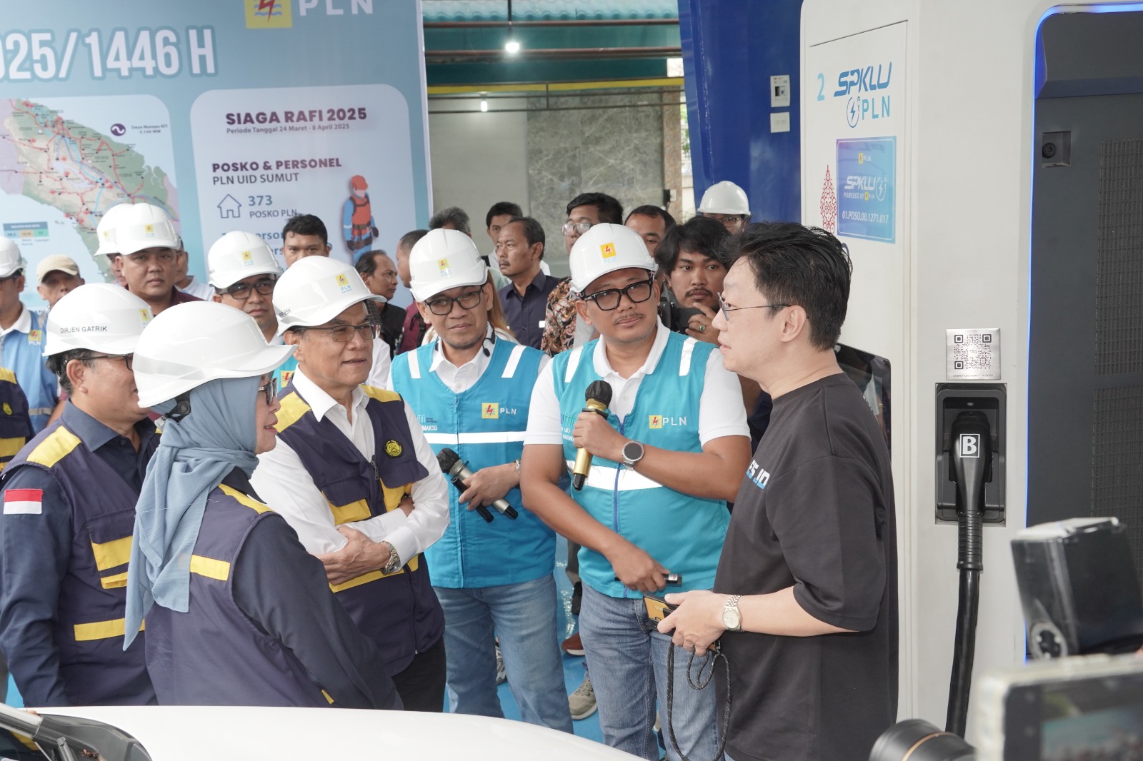 Rombongan kunjungan Kementerian ESDM saat berbincang dengan salah satu pengguna kendaraan listrik yang sedang melakukan pengecasan.