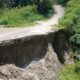 PEJALAN KAKI tengah melintasi jalan desa yang longsor, tepatnya di Dusun III, Desa Dolokmargu, Kecamatan Lintongnihuta, Kab. Humbahas, Sumatera Utara. Waspada/Andi Siregar