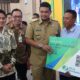 GUBSU Bobby Nasution menyerahkan kartu kepesertaan Badan Penyelenggara Jaminan Sosial (BPJS) untuk nelayan di Pendopo Jentera Malay Rumah Dinas Bupati Langkat Kanwil BPJS Ketenagakerjaan Wilayah Sumbagut, I Nyoman Suarjaya, dan Wakil Ketua DPRD Sumut Ricky Antony (kiri). Waspada/Ist