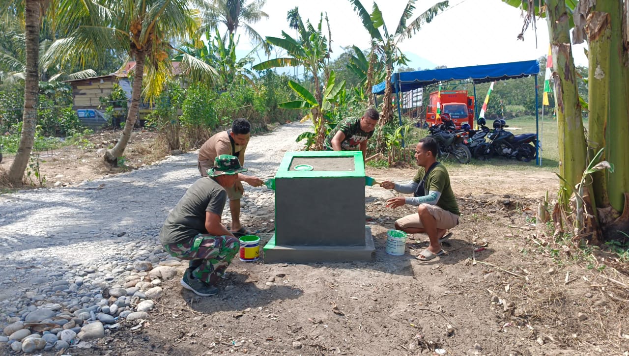 Anggota Satgas Rampungkan Cat Tugu Prasasti TMMD