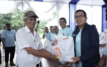 Regional CEO Bank Mandiri Region I/Sumatera 1 I Gede Raka Arimbawa secara simbolis menyerahkan paket sembako murah pada Program Pasar Murah Mandiri kepada salah seorang warga.