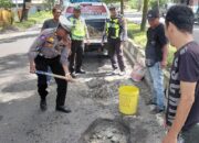 Personel Sat Lantas Polres Langkat Tambal Jalan Berlubang 