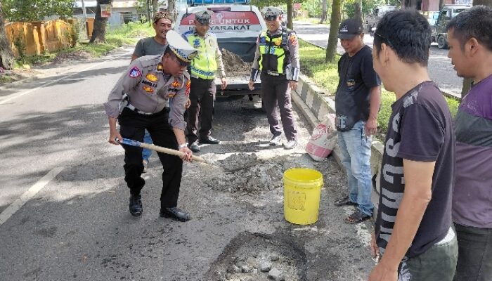 Personel Sat Lantas Polres Langkat Tambal Jalan Berlubang 