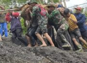 Tiga Anggota TNI Bersama Warga Evakuasi Jenazah Korban Sakit Di Daerah Banjir Takengon