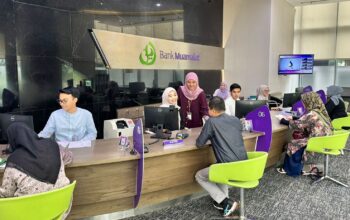 Petugas security PT Bank Muamalat Indonesia Tbk menyambut nasabah yang akan melakukan transaksi di kantor cabang Muamalat Tower, Jakarta, Jumat (2/1/2026).