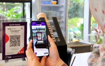 Karyawan melakukan pembayaran menggunakan fitur Quick Response Code Indonesian Standard atau QRIS di aplikasi mobile banking Muamalat DIN di Jakarta, Selasa (6/1/2026). Jumlah transaksi via QRIS Muamalat DIN per November 2025 tercatat lebih dari 5 juta atau tumbuh sekitar 89,37% secara year on year (yoy). Lonjakan tersebut diikuti dengan kenaikan volume transaksi pada periode yang sama yaitu sebesar 71,06% (yoy).